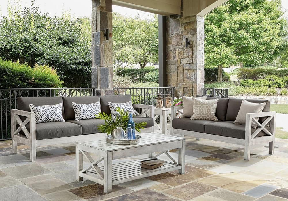 A patio with a white couch and coffee table